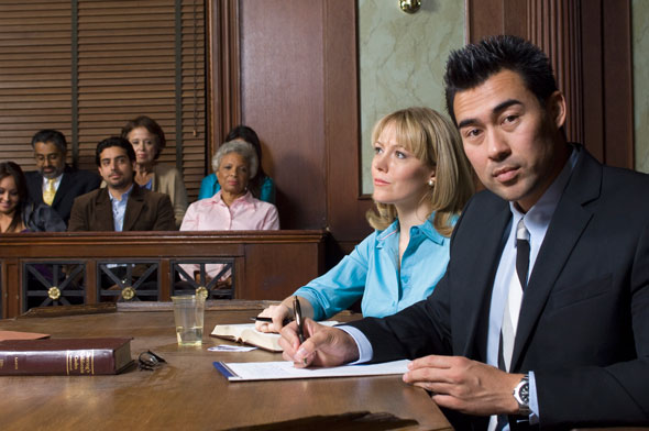 Zwei Anwälte sitzen nebeneinander vor Gericht an einem Tisch